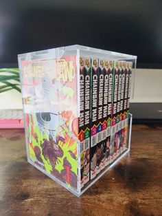 a clear box with comic books inside on a wooden table