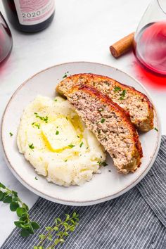 meatloaf and mashed potatoes on a white plate with red wine in the background