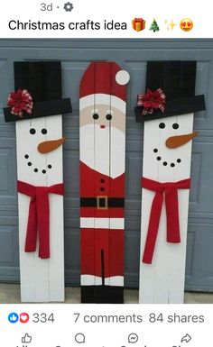 two snowmen made out of wooden planks with santa clause on them and red bows