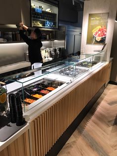 a man standing in front of a counter filled with food