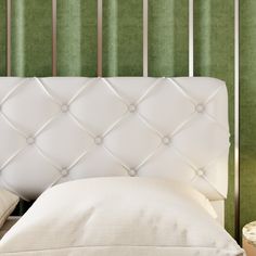 the headboard of a bed with green wallpaper and white pillows in front of it