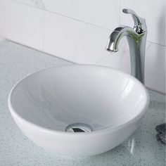 a white bowl sink sitting on top of a counter next to a faucet