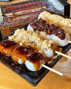 some kind of food that is on a plate with toothpicks and sauces