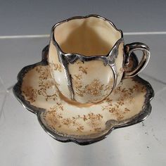 an antique tea cup and saucer on a table