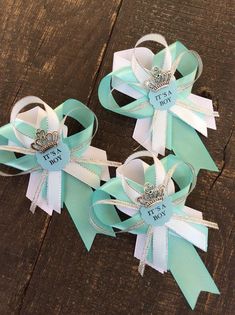 two blue and white bows with tiaras on them sitting next to each other in front of a wooden table