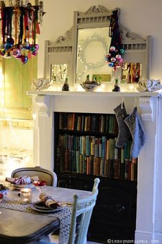 a dining room table and chairs in front of a fireplace with christmas decorations on it