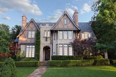 a large house with hedges in front of it