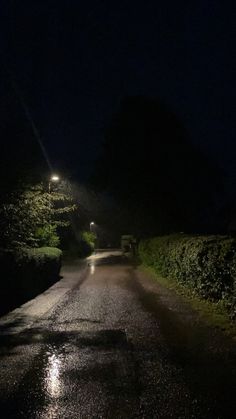 an empty road at night with the lights on