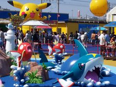 people are standing around in front of some fake sharks and other animals at an amusement park