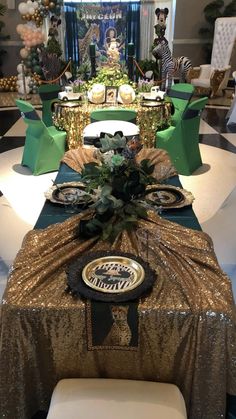 a table set up for a party with green, gold and white decorations on it