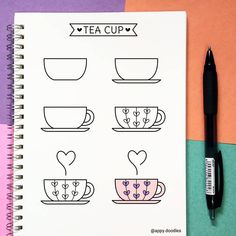 a notebook with tea cups on it next to a pen