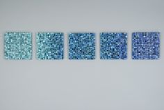 four pieces of blue glass mosaic tile on a wall