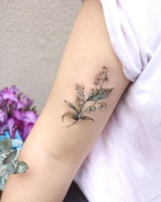 a woman's arm with a flower tattoo on the left side of her arm