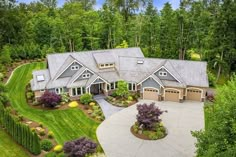 an aerial view of a large home surrounded by trees and shrubs in the middle of a wooded area