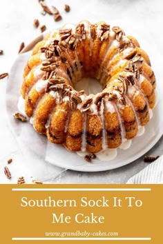 a bundt cake with icing and pecans around it on a white plate