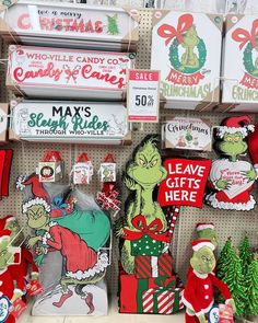 the grinch christmas decorations are on display for sale in a store with santa hats and stockings