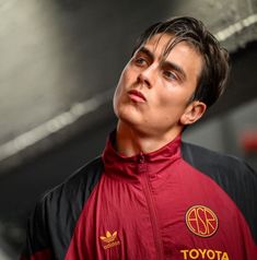 a man in a red and black jacket looking up