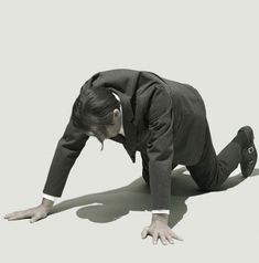 a man in a suit and tie is bending over