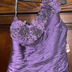 a purple dress hanging on a wooden door