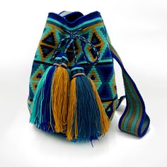 This unique summer bag, crafted in a boho chic style, was meticulously handwoven by the indigenous Wayuu community of Colombia. Designed to endure the test of time, it carries with it the promise of good fortune and cherished memories for a lifetime.This is an unlined drawstring crochet bag Size: 11"H x 9"W, circle bottom Strap has a 21" drop but is soft enough to be knotted and worn as a short shoulder or handle. Handmade Blue Pouch Shoulder Bag, Artisan Blue Tote Bag, Traditional Blue Shoulder Bag For Daily Use, Blue Handwoven Beach Bag For Travel, Blue Handwoven Crochet Bag For Vacation, Handwoven Multicolor Beach Bag For Festival, Multicolor Handwoven Beach Bag For Festival, Bohemian Blue Beach Bag For Festival, Bohemian Blue Bucket Beach Bag