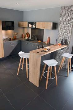 a kitchen with two stools and an island in the middle of the flooring