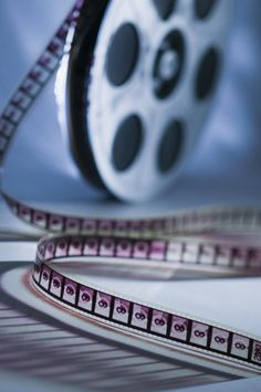 a roll of film sitting on top of a white table next to a reel of tape