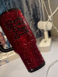 a person holding a red sequinized cup