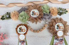 some flowers are hanging on the wall with ribbons and tags attached to each flower headband