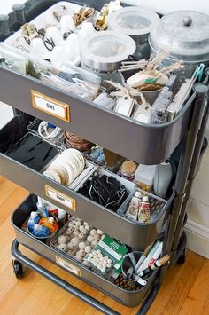 a metal cart filled with lots of clutter on top of a hard wood floor