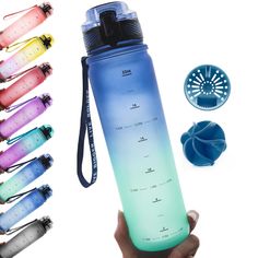 a hand holding a water bottle with several different colors on it and various accessories around it