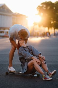 a man kneeling down next to a woman on a skateboard