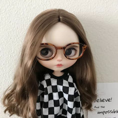 a close up of a doll wearing glasses