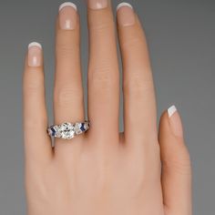 a woman's hand with a diamond and sapphire ring