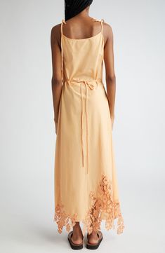 Fresh from the label's Midsummer Mystic capsule collection, this cotton slipdress showcases slender tie straps and a lace-edged handkerchief hem. A pastel orange hue and wrap-inspired silhouette complete this number. 42 1/2" to 47 1/2" center front length (size 34EU) Scoop neck Adjustable tie straps Attached waist tie Unlined 100% cotton with 100% polyester contrast Dry clean Imported Designer Clothing Cotton Maxi Dress With Tie Fastening For Daywear, Cotton Daywear Dresses With Tie Fastening, Cotton Slip Dress For Spring Vacation, Summer Cotton Maxi Dress With Tie Fastening, Elegant Sleeveless Cotton Slip Dress, Elegant Cotton Maxi Dress With Tie Straps, Summer Lace Slip Dress For Daywear, Spring Daywear Slip Dress With Tie Back, Cotton Sundress Slip Dress For Spring