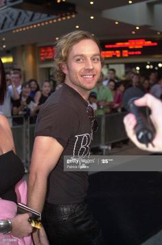 a man and woman standing in front of a crowd at an event holding cell phones