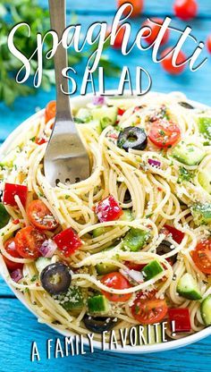 spaghetti salad in a white bowl with a fork on the side and blue wooden table