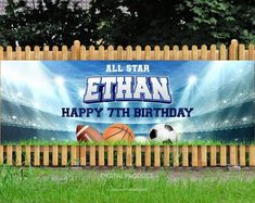 a wooden fence with a sign that says cthan happy 7th birthday and soccer balls in the grass