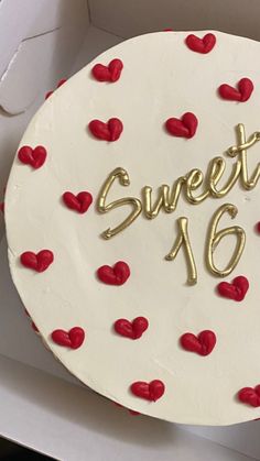 a white cake with red hearts and the words sweet 16 on it in gold lettering