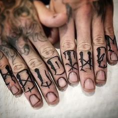 two hands with tattoos and letters on them