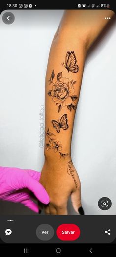 a woman's arm with flowers and butterflies tattooed on the side of her arm