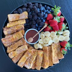 a platter with bananas, strawberries, blueberries, and other fruit on it