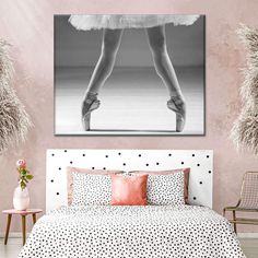 a black and white photo of a ballerina's feet on a bed with polka dot sheets