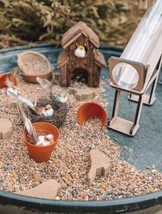 a bird's nest with eggs and spoons in it on top of gravel