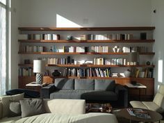 a living room filled with lots of furniture and bookshelves full of books on shelves