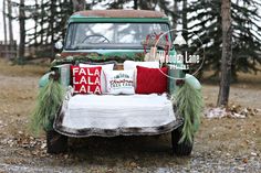 an old truck is decorated with christmas pillows and evergreen garlands for the holiday season