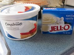 a container of jello next to a carton of yogurt on a counter