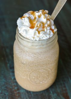 a glass jar filled with whipped cream and caramel