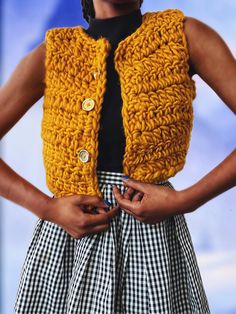 a woman wearing a yellow knitted vest