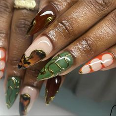 a woman's hands with colorful manies and gold accents on them, including an animal - print design