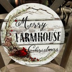 a wooden sign that says merry farmhouse christmas with a cardinal and pine cones on it